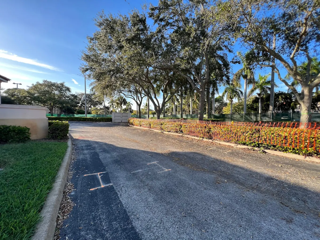 Large-scale landscaping project with safety fencing and mature trees