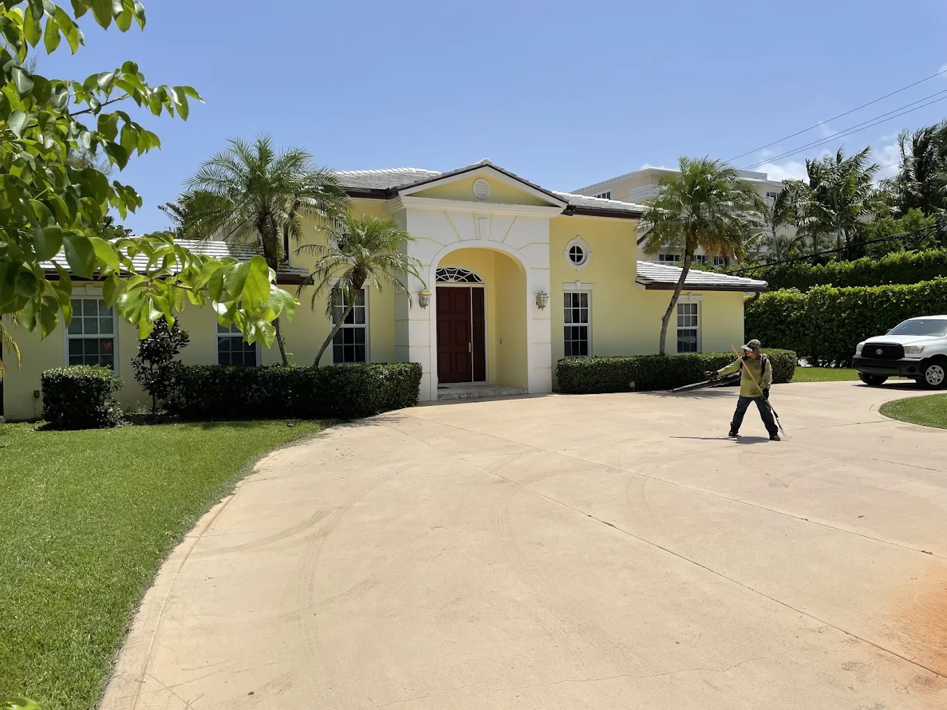 Mediterranean-style home with professional lawn maintenance in progress
